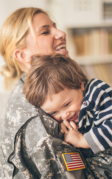 Smiling military veteran holding child - Tulane SoPA