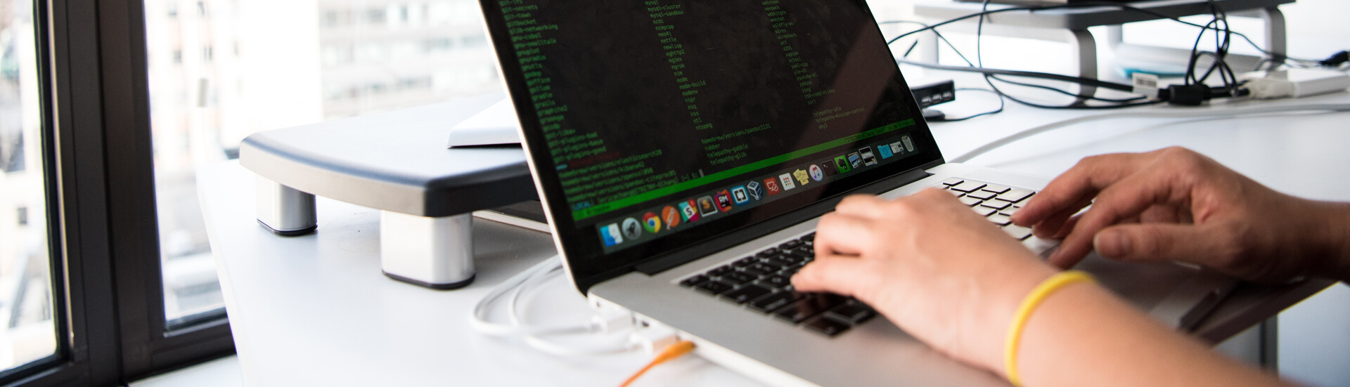 Closeup of student working on a laptop at a desk - Tulane SoPA