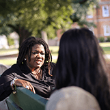 Tulane SoPA students talking on a bench