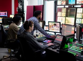 Humanities graduates working at a work station with many screens - Tulane School of Professional Advancement