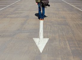 Person standing in front of an arrow representing Tulane School of Professional Advancement's continuing studies programs in New Orleans, LA