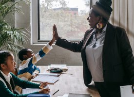 A teacher giving students a high five