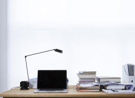 A desk with a laptop and books