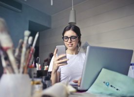 A student in an art room looking at their phone