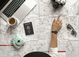 A person looking at a map with other travel accessories