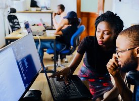 People looking at code together on a computer