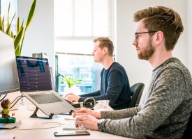 Two men working on desktop computers