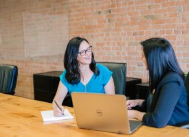 Two woman talking in a conference room