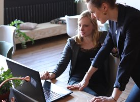 Two women professionals working on a laptop