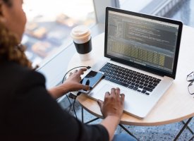 A woman working on code on her laptop