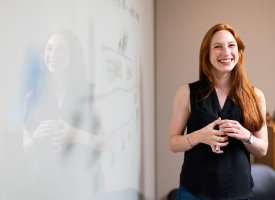 A teacher smiling by the whiteboard