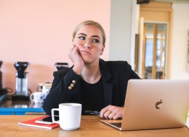 A woman thinking in front of her computer